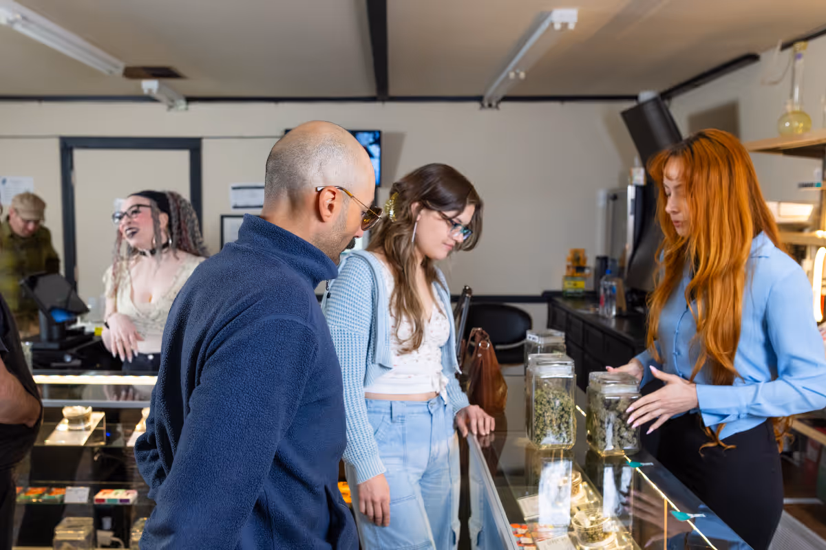 Customers at a dispensary looking at products with a budtender