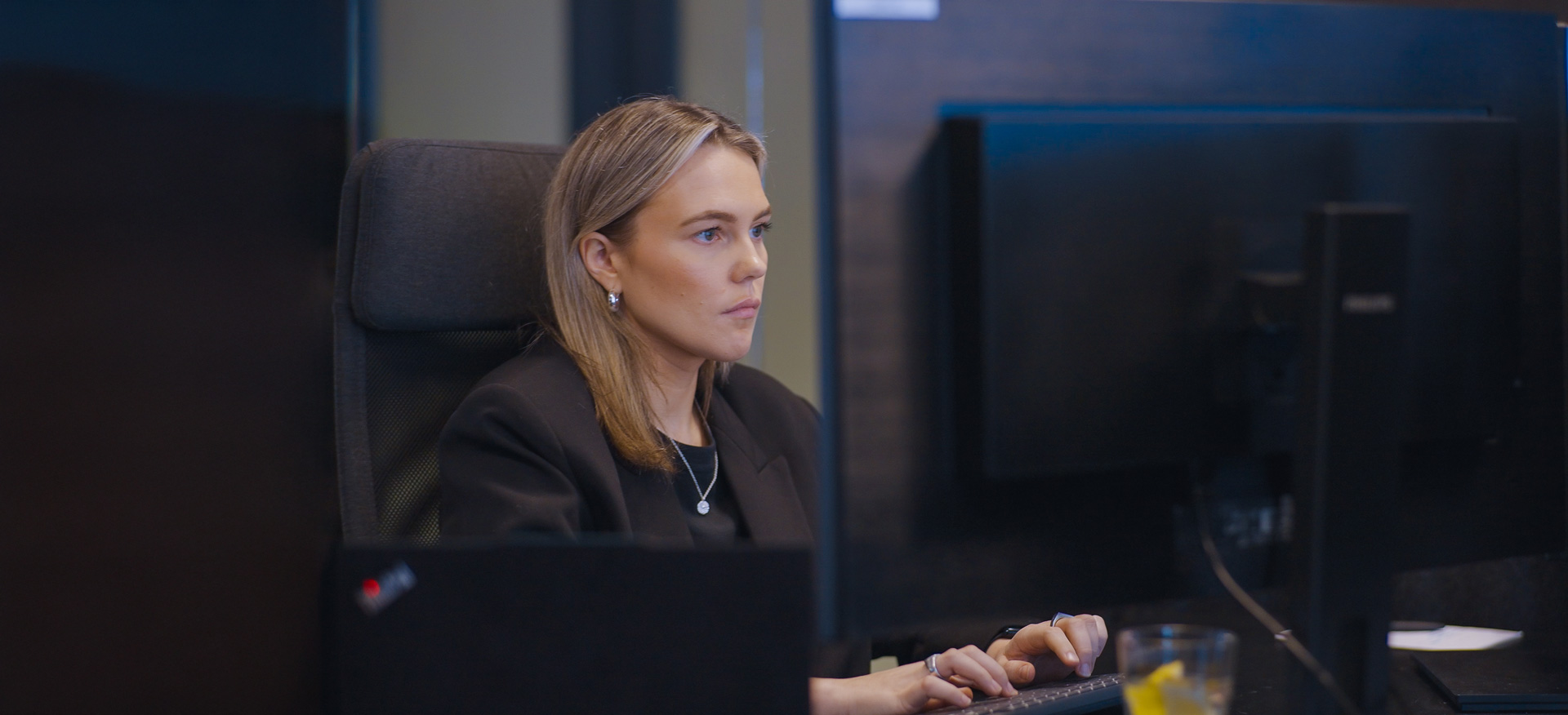 Person sitting by screen in an office