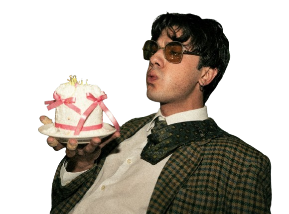Man wearing sunglasses holding a small birthday cake with lit candles.