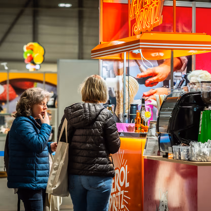 Messebesucherinnen am Aperol-Spritz-Stand des Eistechnikcenter