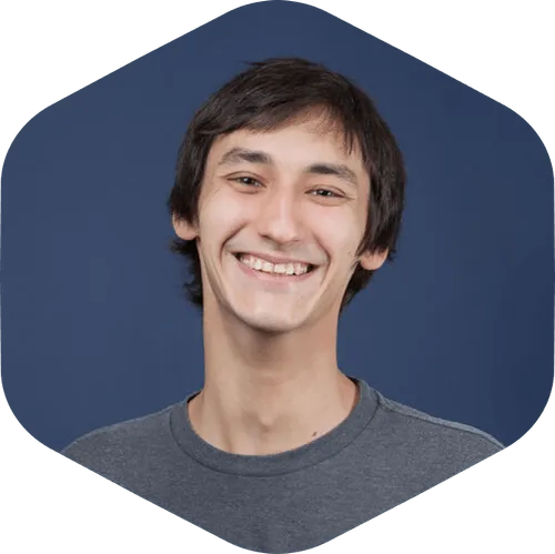 Portrait of Nikita Trishin smiling against a dark blue background.