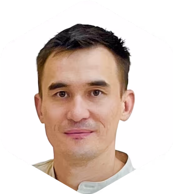 Portrait of speaker Rustam with short dark hair and a light shirt.