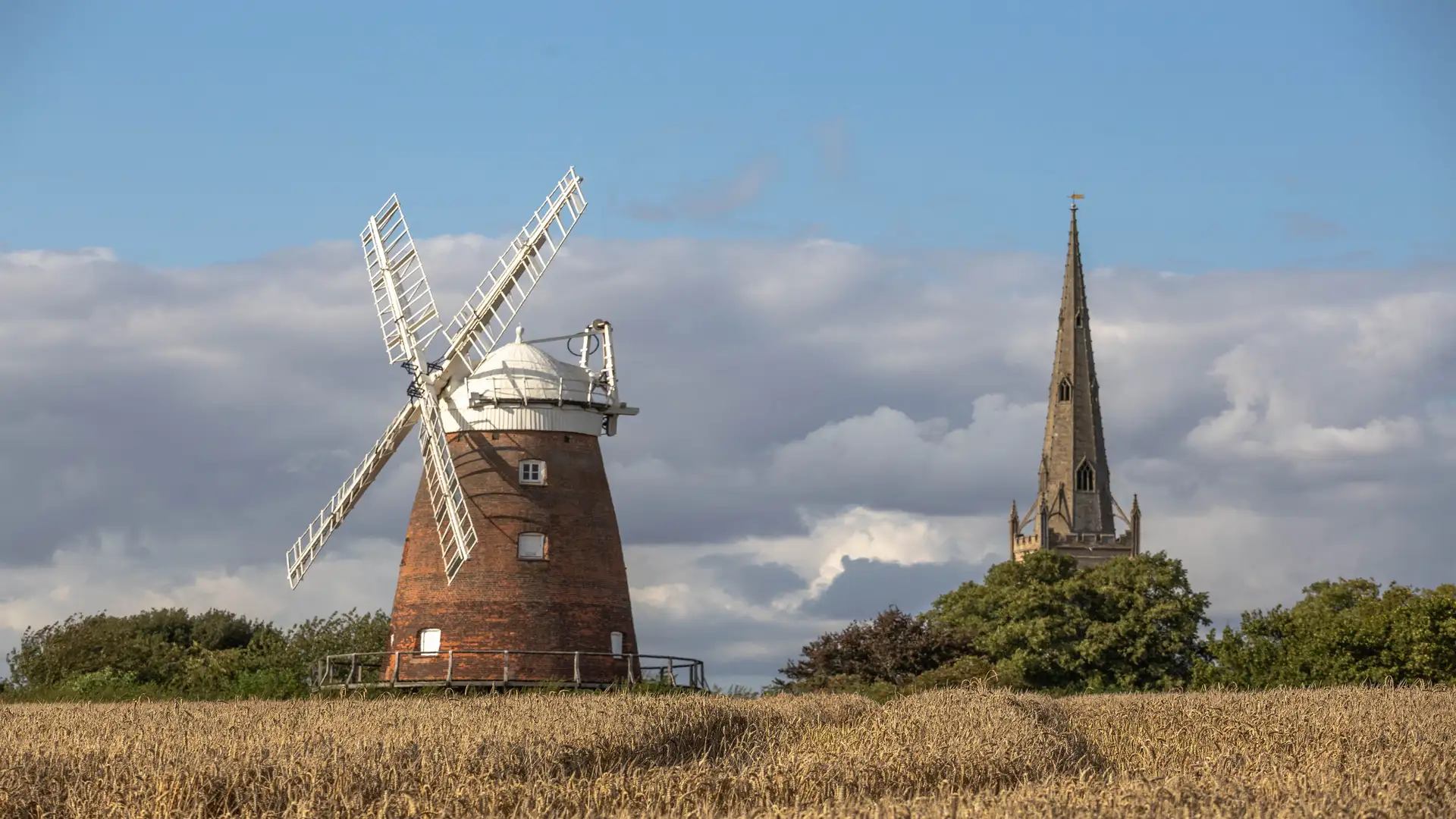 View of Thaxted Windmill across open farmland on a sunny day.