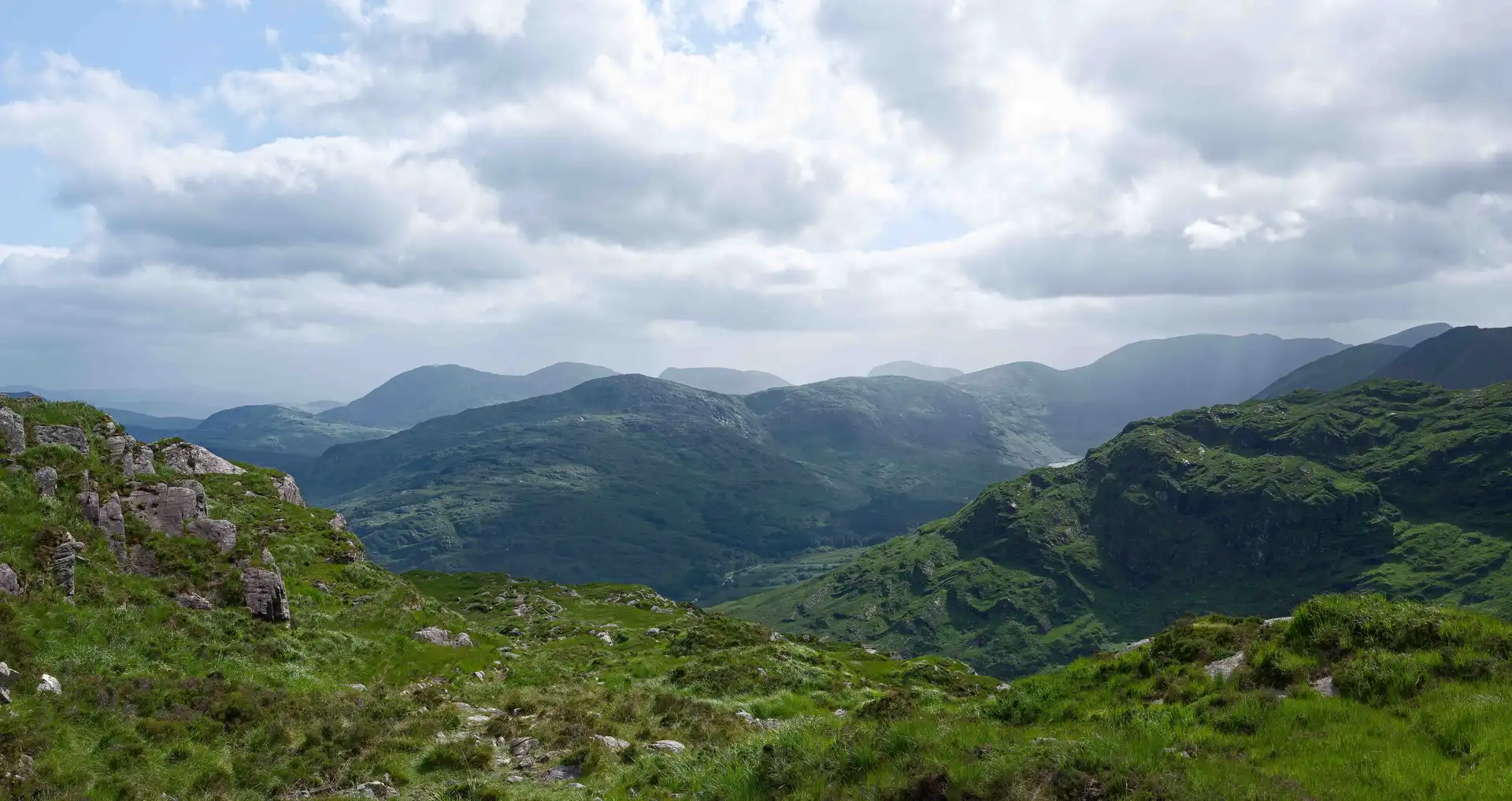 Overlook of lush green mountains and winding valley path in the Gap of Dunloe, County Kerry, Ireland — a famous walking and hiking destination on the Kerry Way.