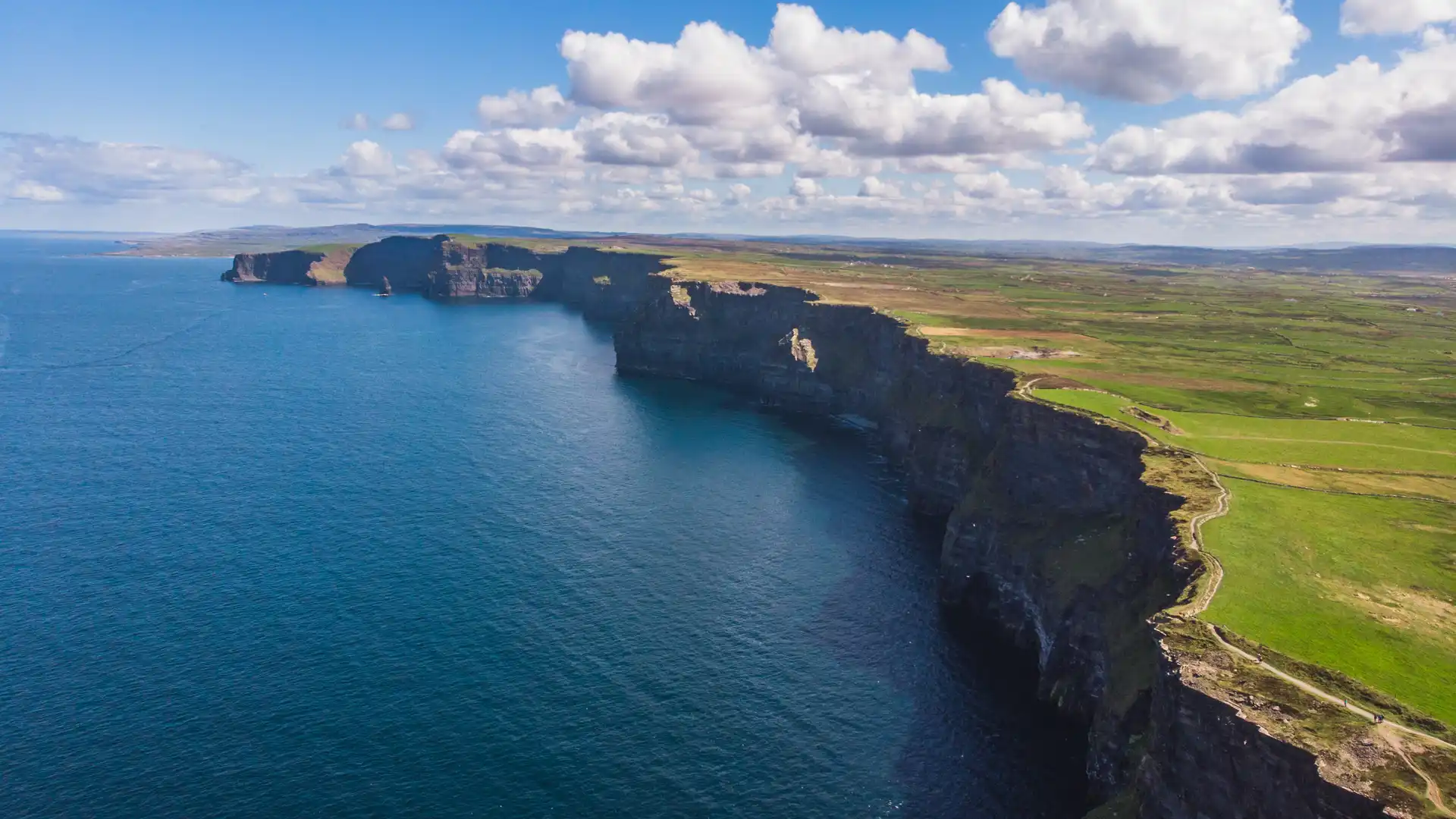 The Cliffs of Moher rising above the Atlantic Ocean with layered limestone cliffs, sea stack, and dramatic coastal views in County Clare, Ireland.