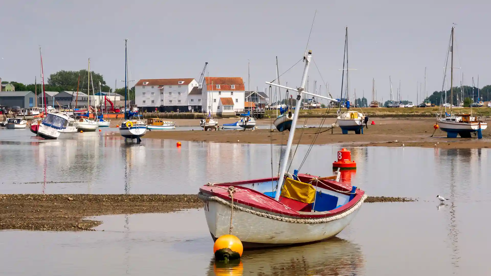 Boats moored on the Deben Estuary at Woodbridge with the Tide Mill, Suffolk Coast Path.