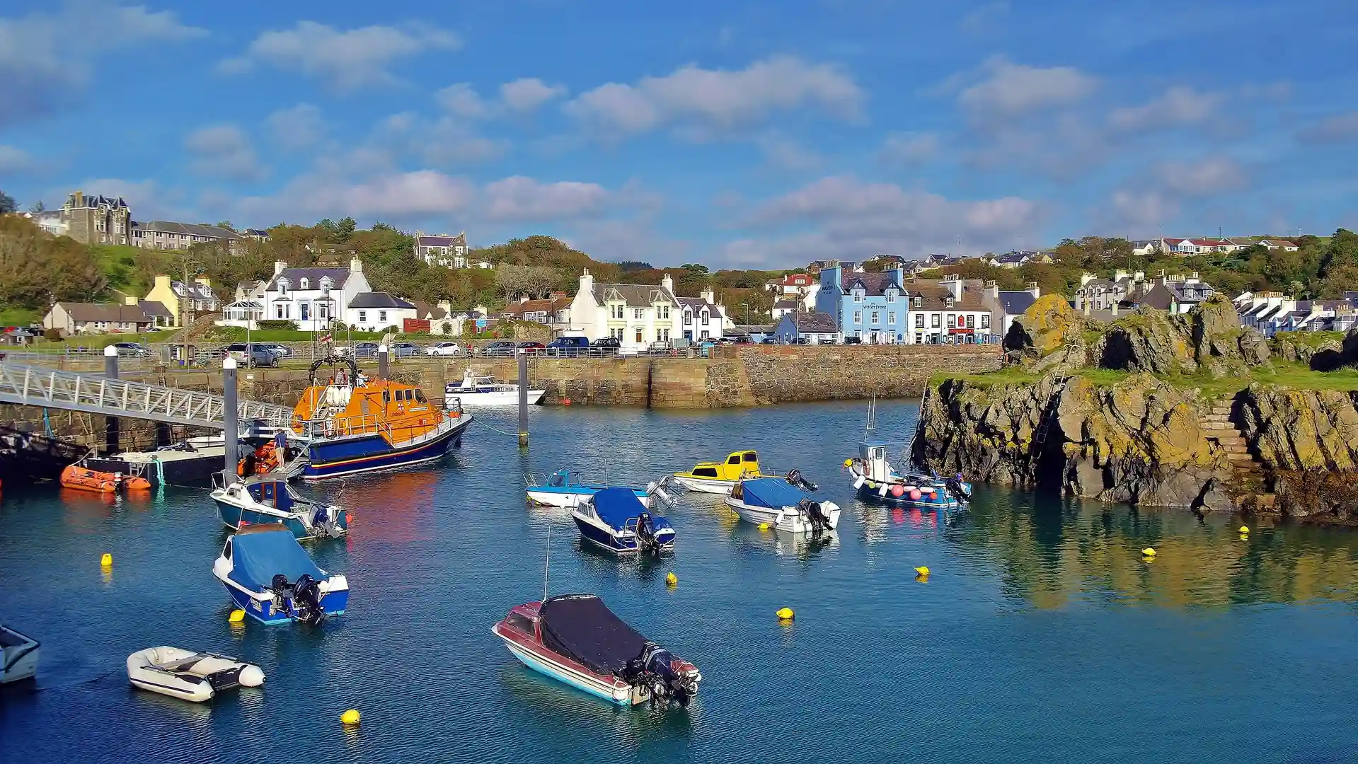 Boats moored in the harbour at Portpatrick, a colourful seaside village on the Rhins of Galloway Coast Path in southwest Scotland.