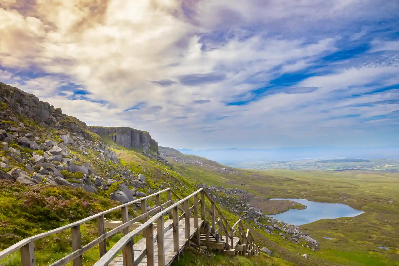 View from the Cuilcagh Mountain Boardwalk, known as the “Stairway to Heaven,” overlooking lakes and moorland in County Fermanagh, Northern Ireland — a popular route for walking holidays and outdoor adventures.