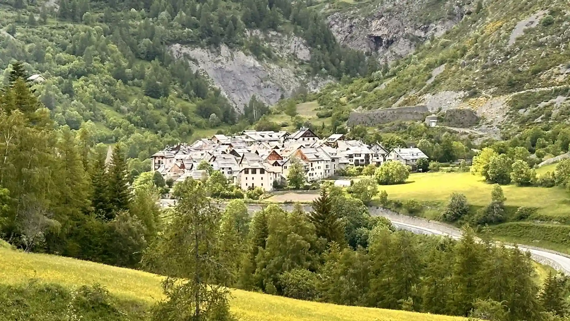 High-altitude village of Saint-Dalmas-le-Selvage in the Haute Tinée, surrounded by alpine meadows and forested slopes in the French Alps.