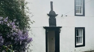 Stone House Farm in St Bees, a traditional whitewashed guesthouse with a flower-filled garden, used by walkers starting the Coast to Coast Path.