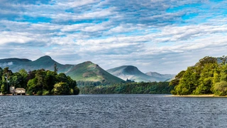 Derwentwater with wooded shoreline and surrounding fells in the Lake District National Park, Cumbria.