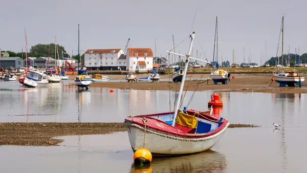 Boats moored on the Deben Estuary at Woodbridge with the historic Tide Mill in the background, Suffolk Coast Path