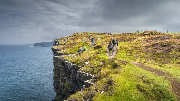 Walkers on the Wild Atlantic Way in County Clare, Ireland, symbolising slow travel and self-guided walking.