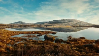 Limestone hills and seasonal wetland reflected in still water in The Burren National Park.