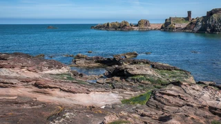Ruins of Dunbar Castle on a rocky outcrop overlooking the harbour and North Sea in East Lothian, Scotland.