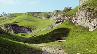 Walkers in a limestone dale on the Limestone Way in the White Peak, Derbyshire.