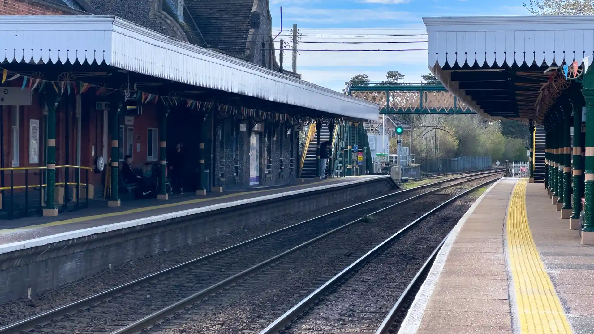 Thetford train station in Norfolk showing platforms, railway tracks, and a footbridge crossing above the line.