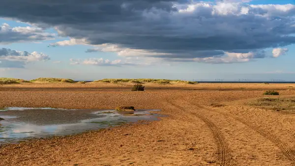 Wide sandy beach and dunes at Holme-next-the-Sea on the North Norfolk coast with open sky and distant sea horizon.