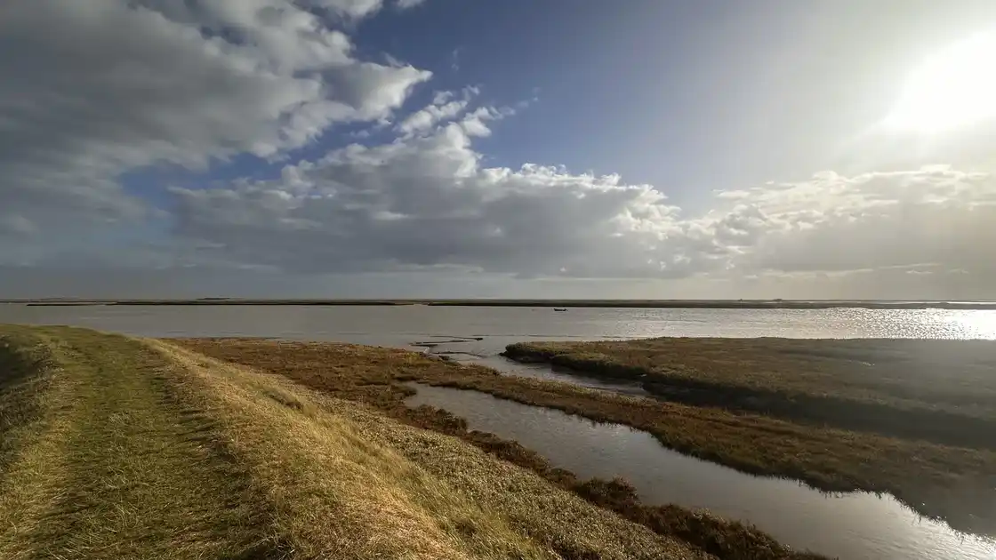 Estuary marshland and tidal creeks with big skies along the Suffolk Coast and Heaths National Landscape.
