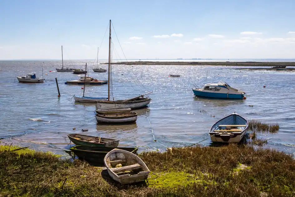 Small boats moored among saltmarsh and tidal waters on the Essex Coast.