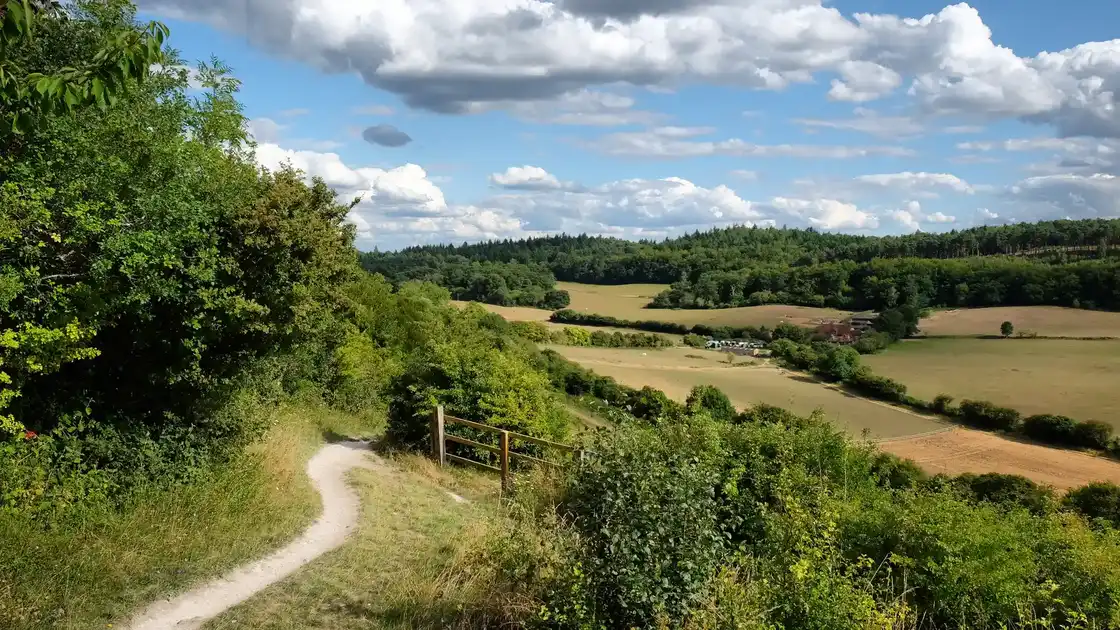 Chalk hillside path overlooking farmland on the North Downs Way.