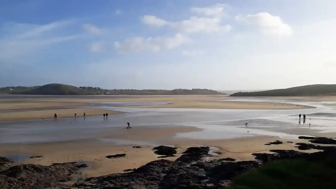 Walkers crossing tidal sands near Padstow on the Saints’ Way in Cornwall.