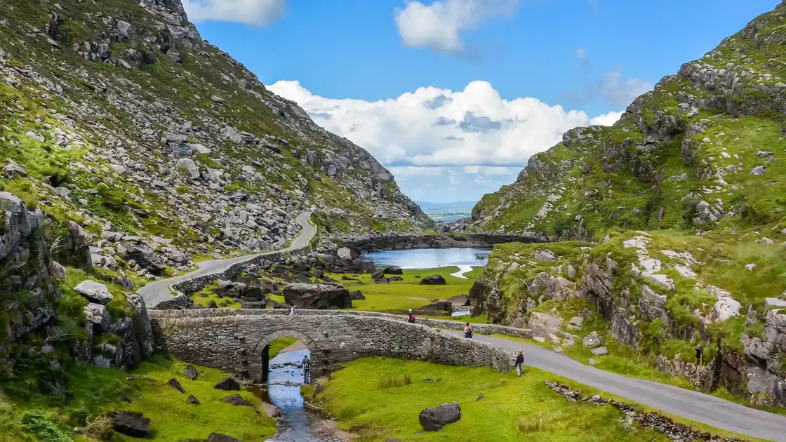 Walkers crossing stone bridge in the Gap of Dunloe on the Kerry Way in County Kerry.