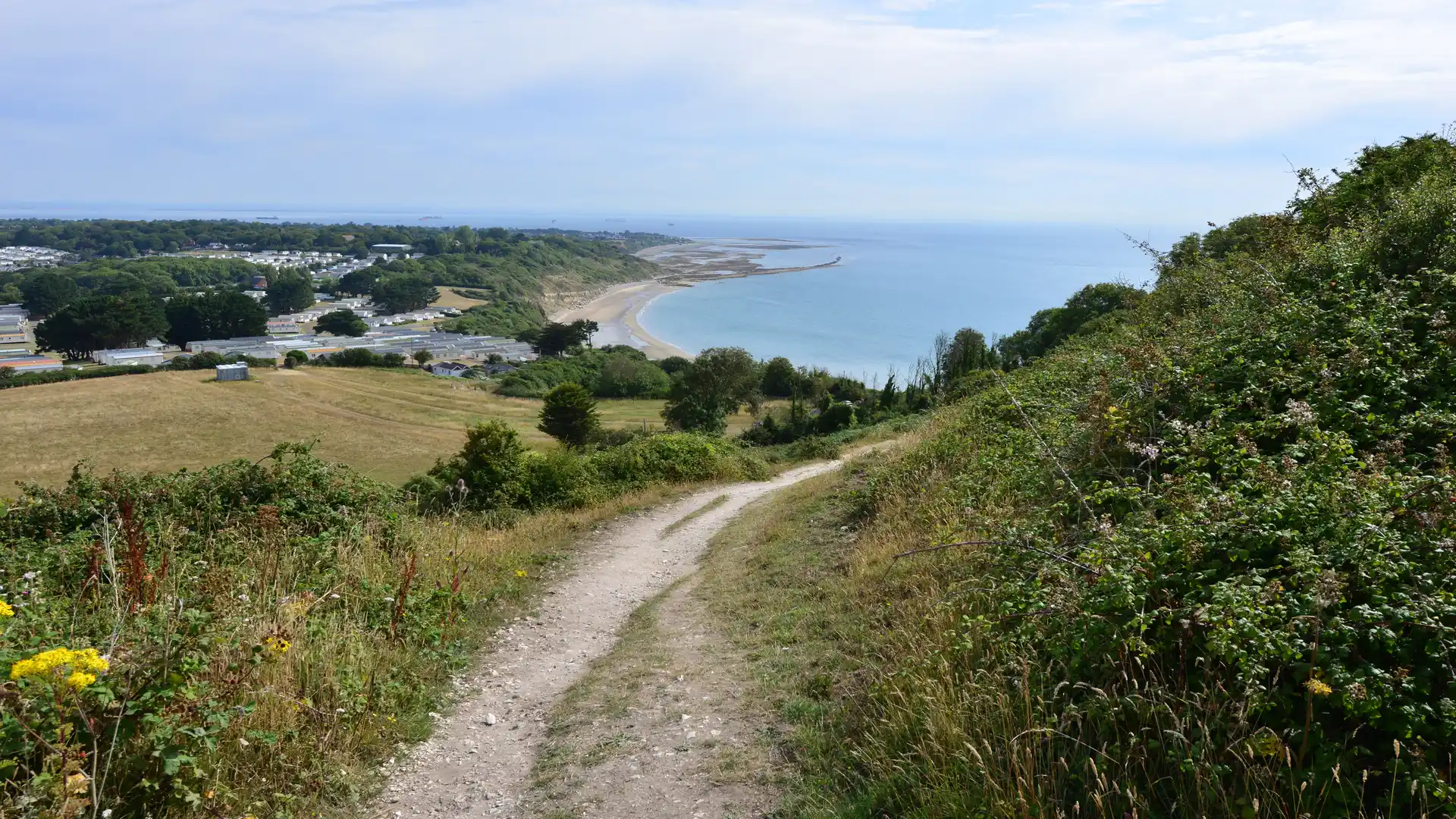 Clifftop path descending toward the shoreline on the Isle of Wight Coastal Path, England.