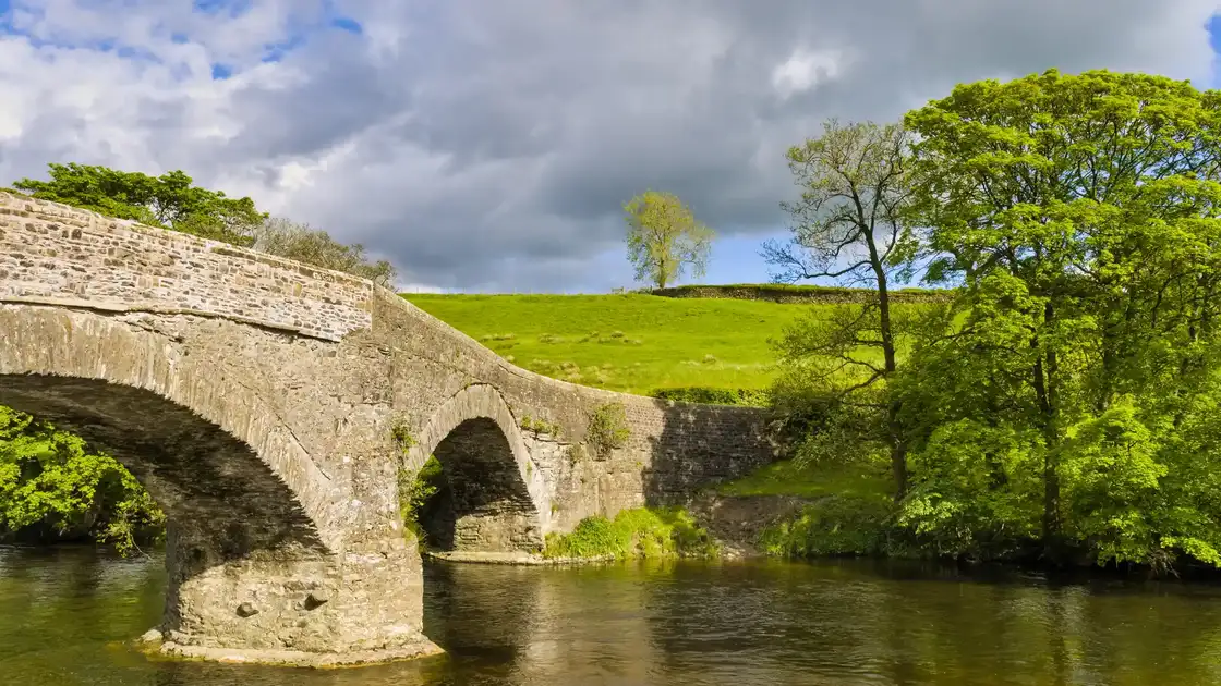 Crook of Lune Bridge crossing the River Lune along the Dales Way, surrounded by woodland and countryside in northern England.