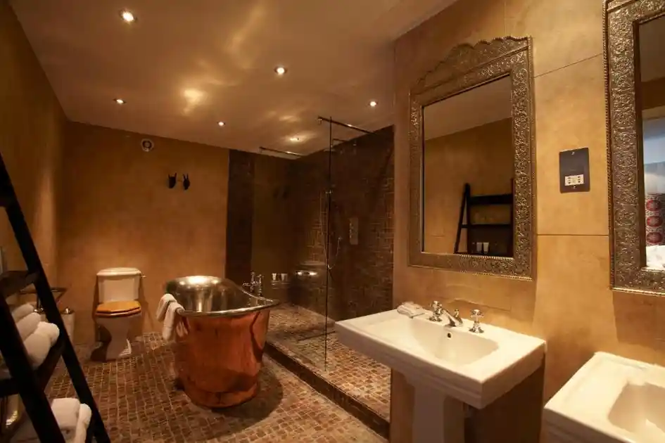 Guest bathroom with freestanding copper bathtub and walk-in shower at The Angel Hotel.
