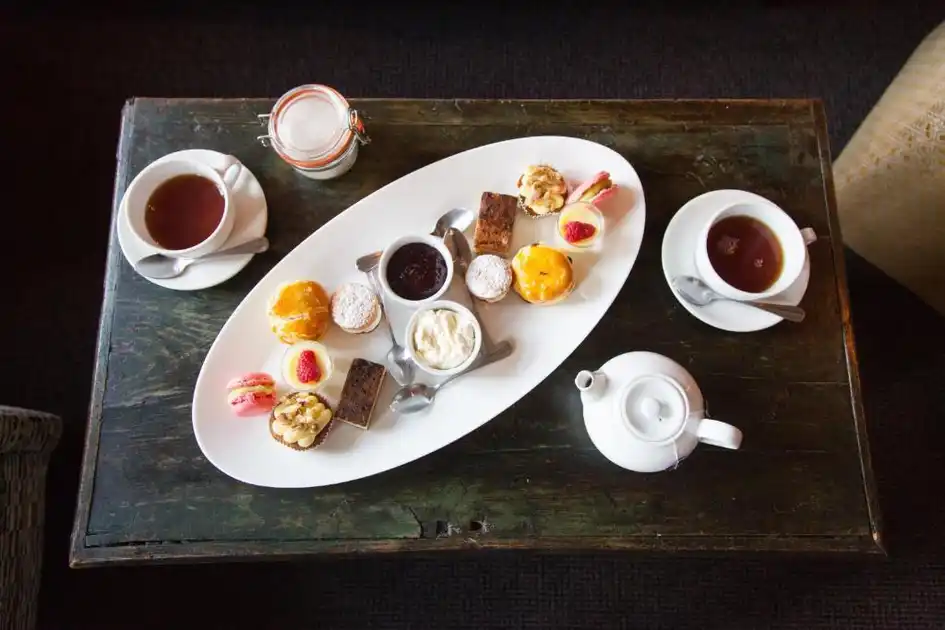 Afternoon tea at The Lifeboat Inn in Thornham, Norfolk, with a selection of cakes, pastries, scones, jam and cream served alongside tea.