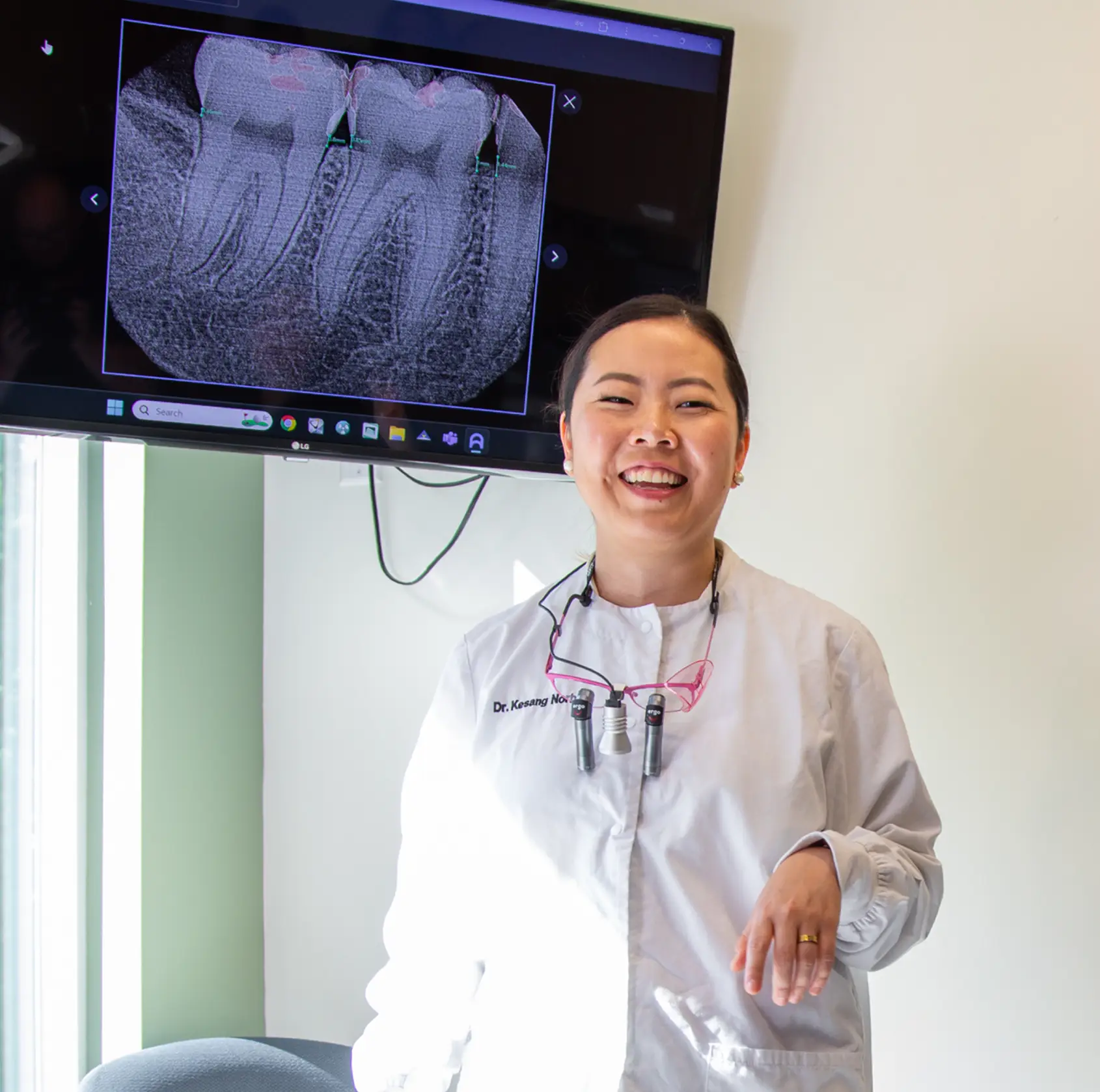 A dentist discusses dental X-rays with a patient in an examination room.
