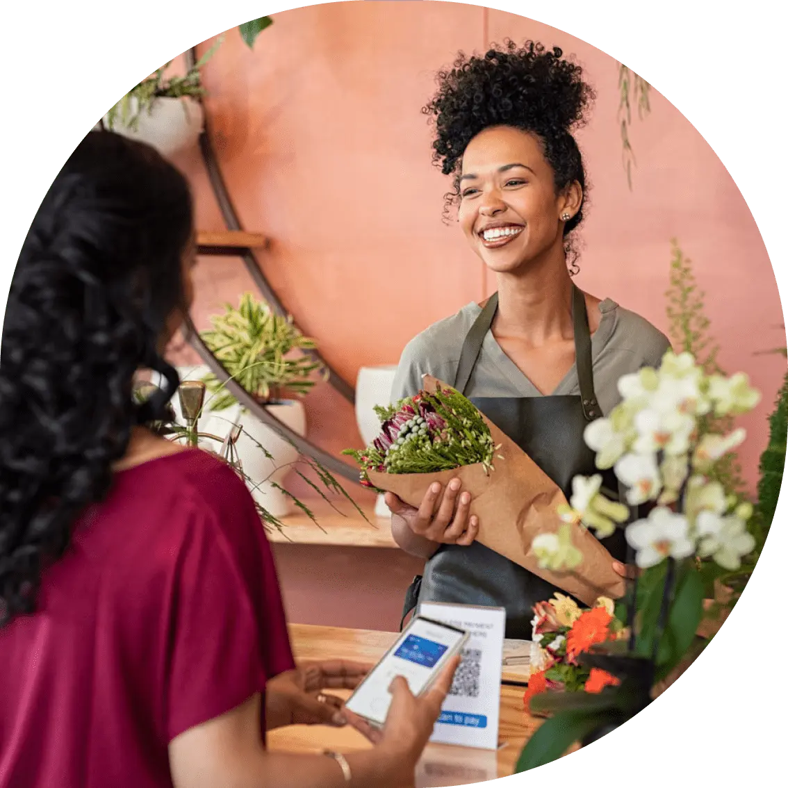A customer paying a happy flower shop owner for her flowers.