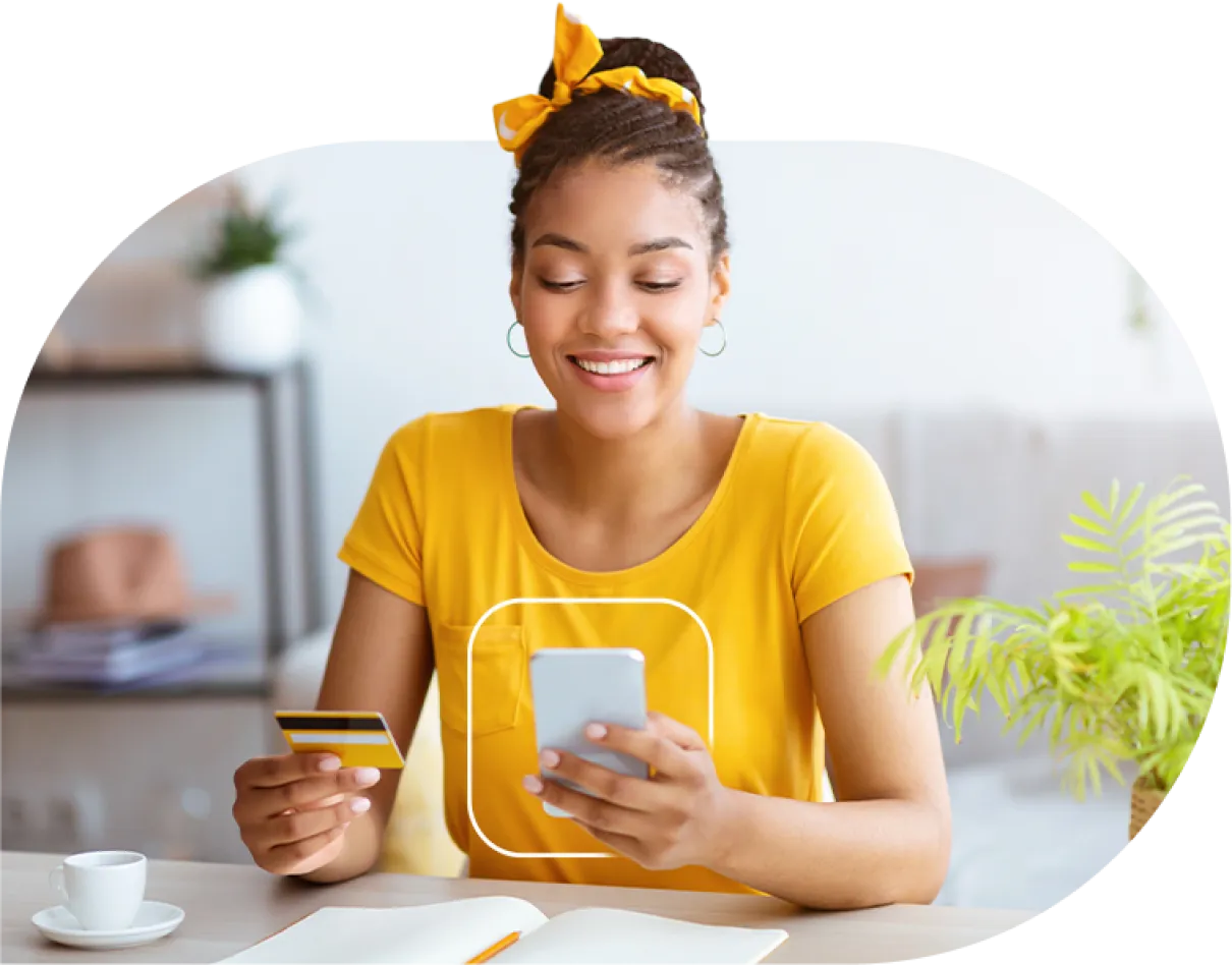 Smiling woman enters her credit card info into her mobile device to online checkout.