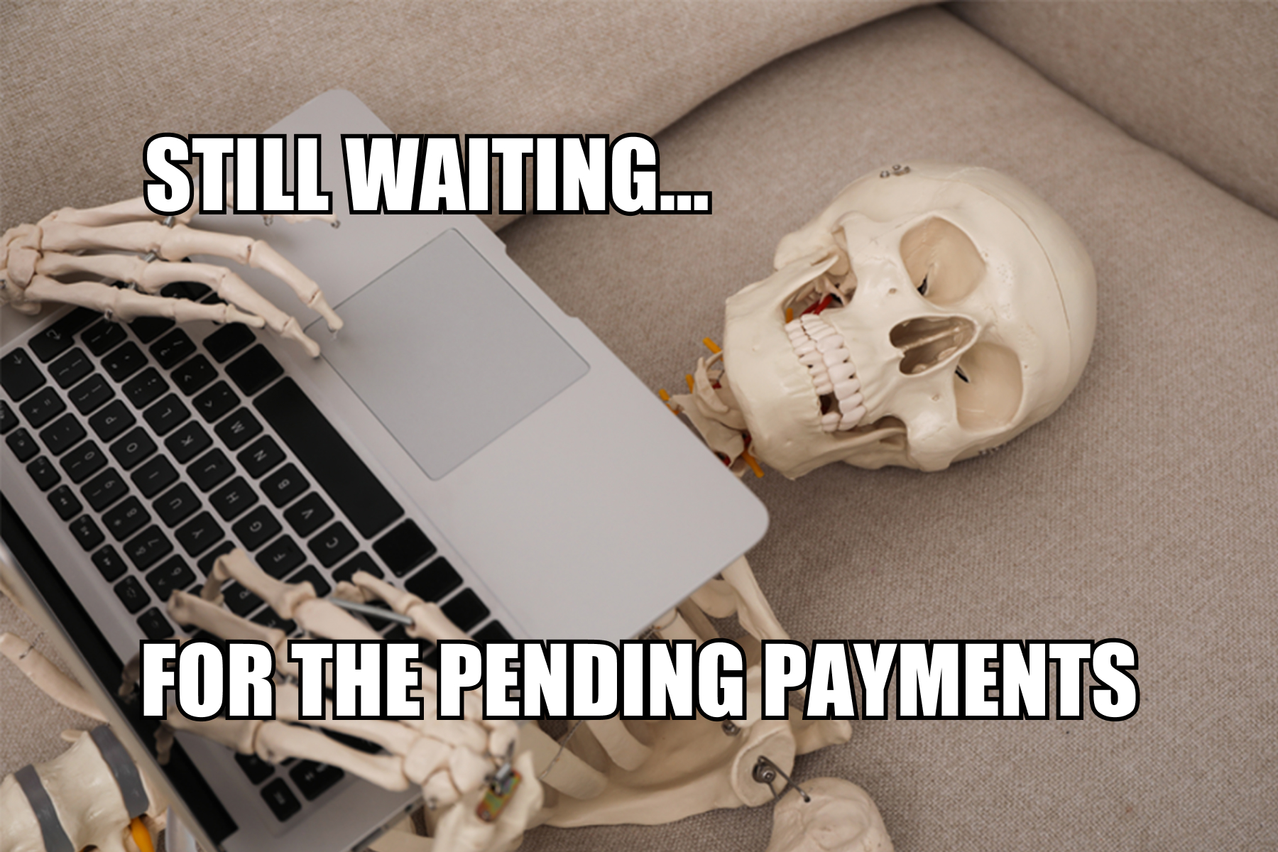 Skeleton lying on a couch with a laptop, humorously illustrating the frustration of waiting for overdue freelance payments.
