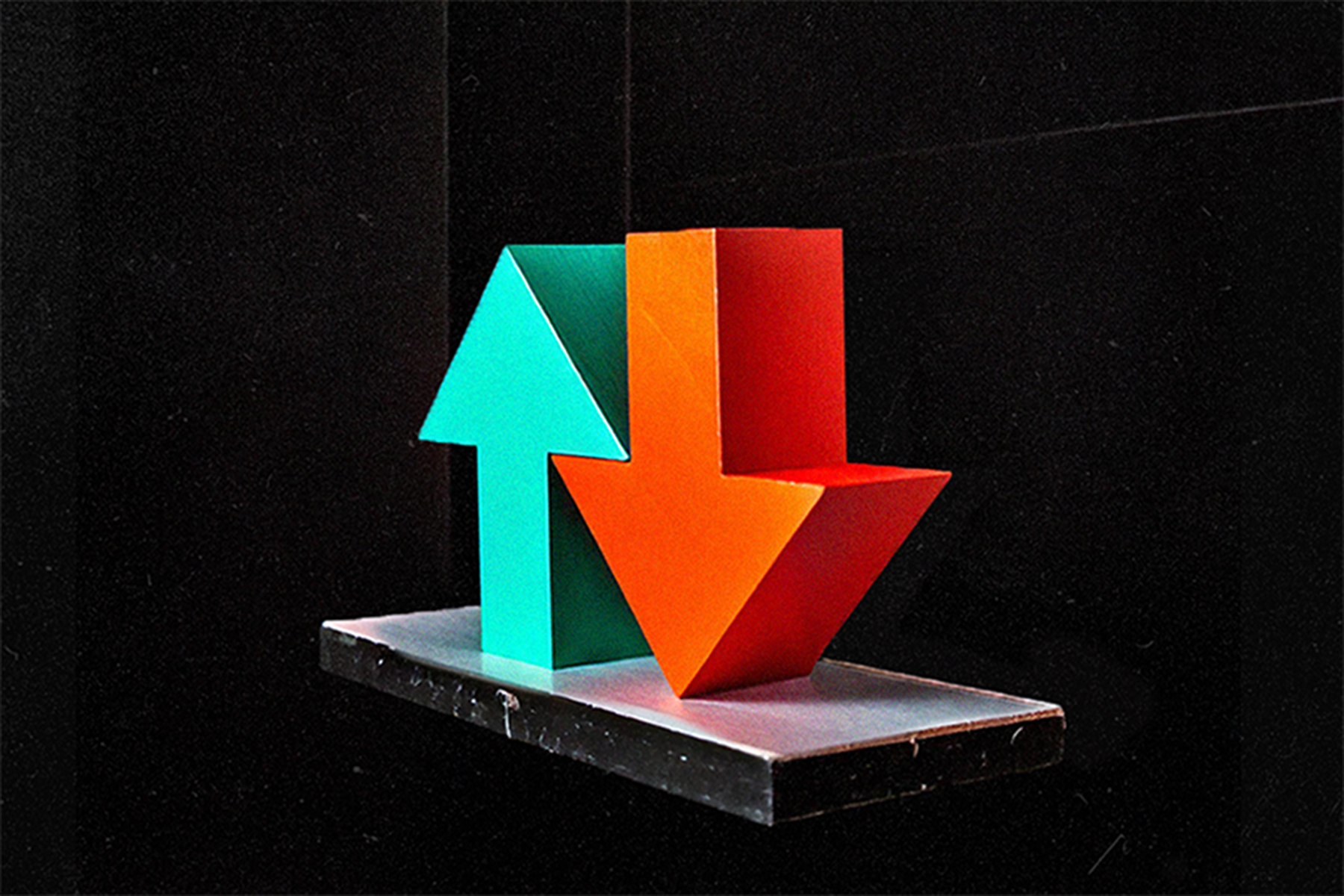 3D arrows representing a rise and fall, as an upward green arrow and a downward orange arrow on a dark background.