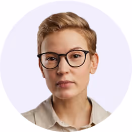 Portrait d'une personne aux cheveux courts blonds, portant des lunettes noires et une chemise beige.