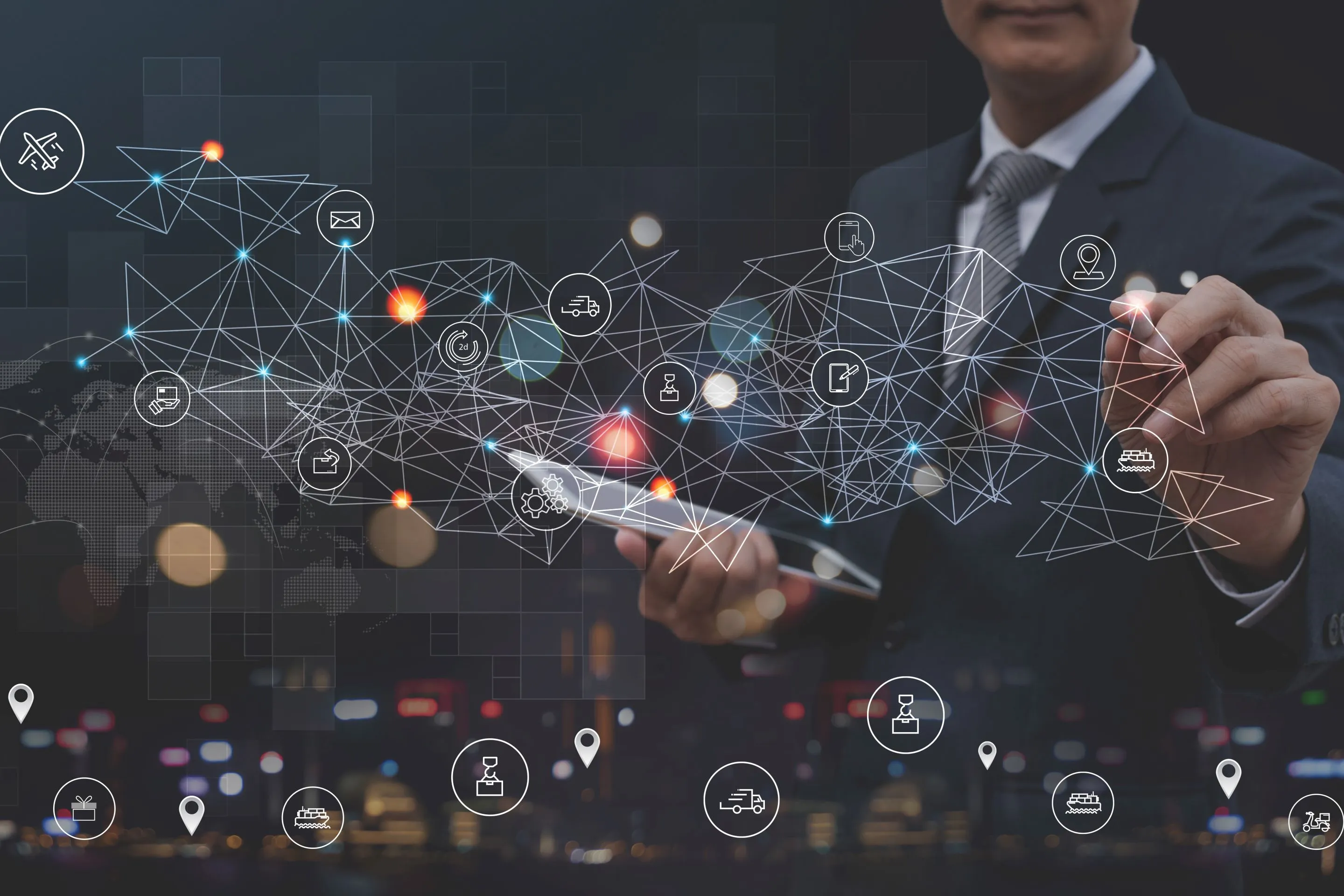 Geschäftsmann im Anzug, der mit einem Touchpen auf ein digitales Netzwerk aus Logistik- und Transportsymbolen über einem Tablet zeigt.