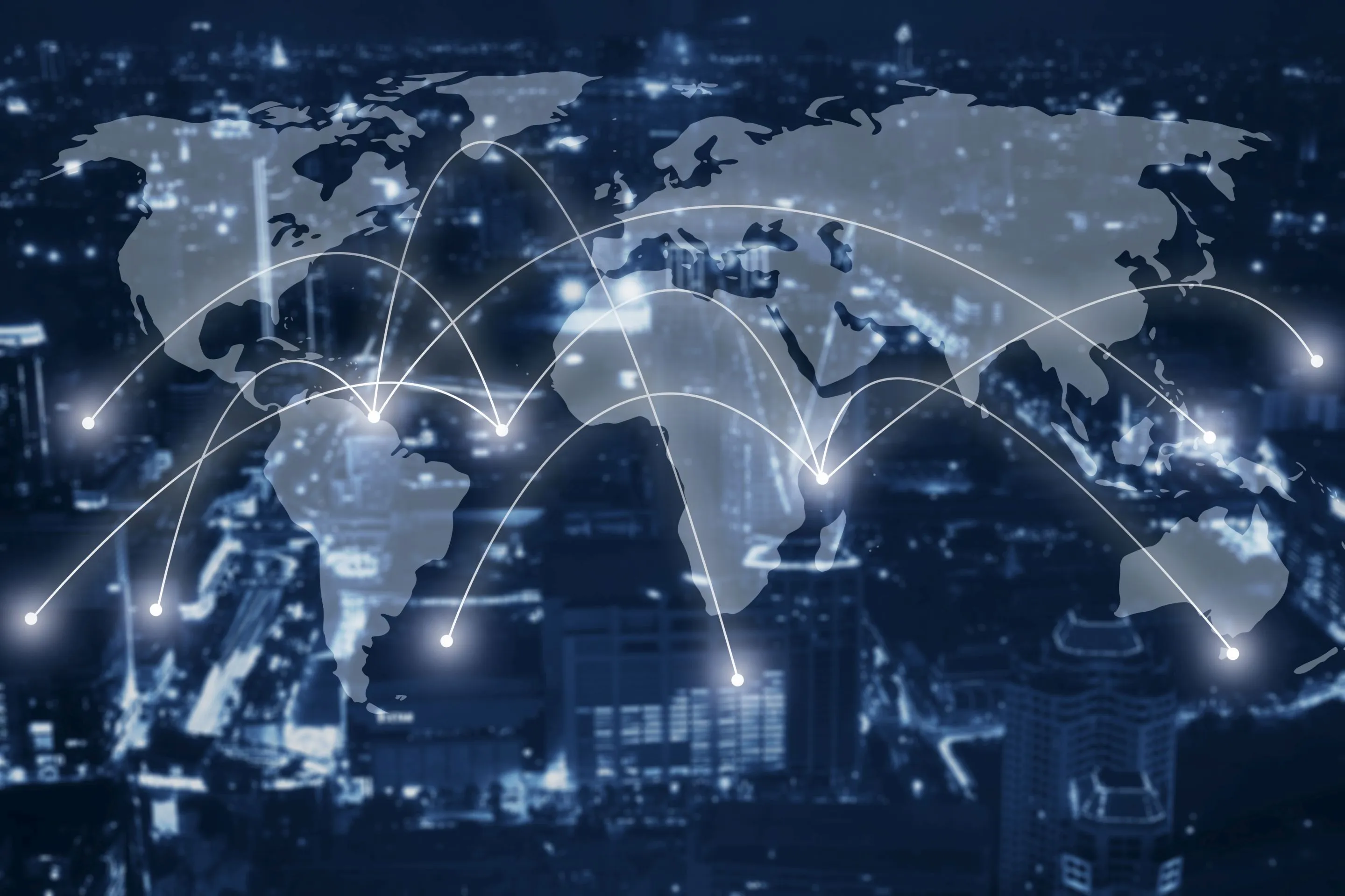 Weltkarte mit leuchtenden Verbindungslinien zwischen verschiedenen Kontinenten vor unscharfem Stadthintergrund bei Nacht.