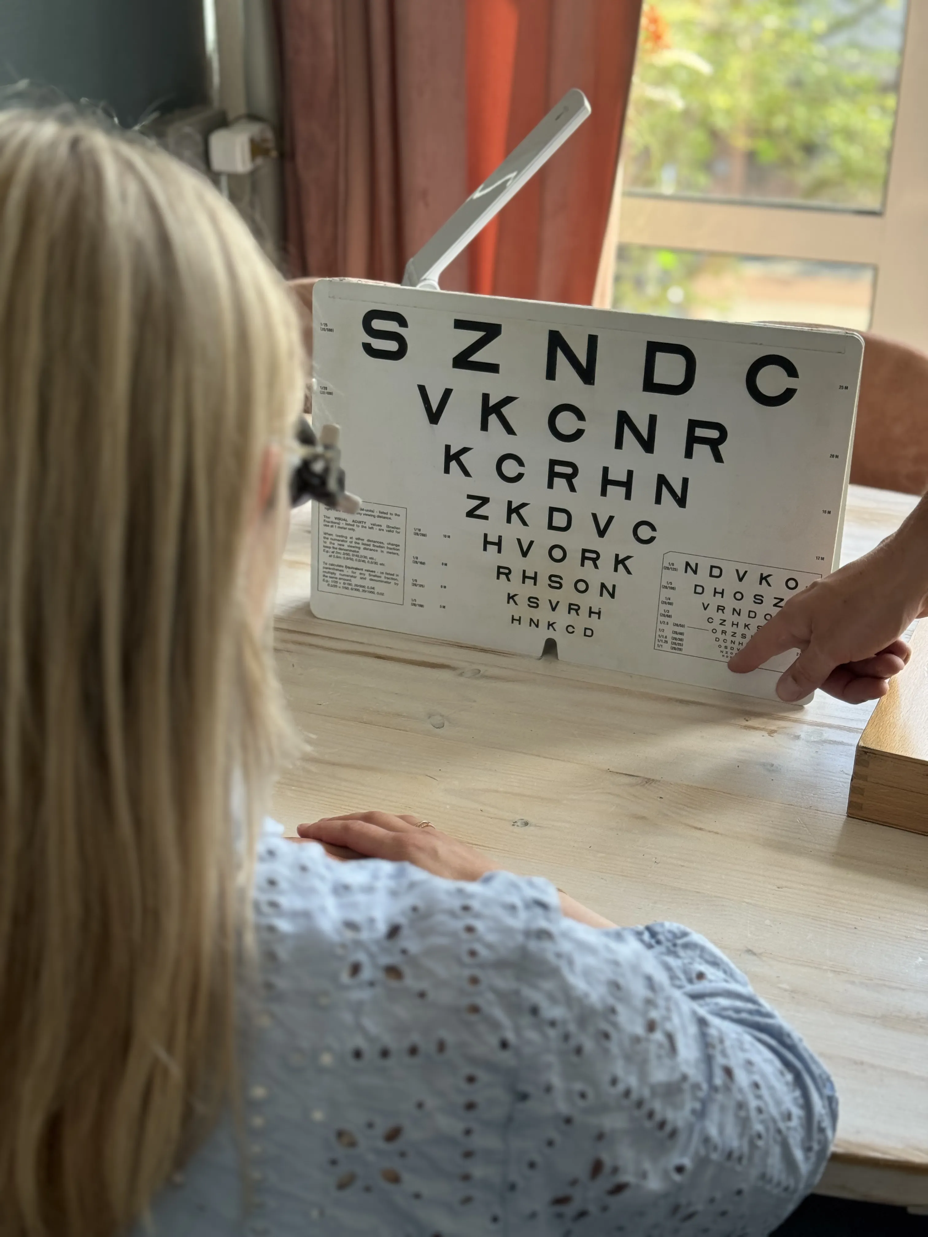 Een cliënt probeert optische hulpmiddelen met een low vision specialist van Low Vision Totaal.