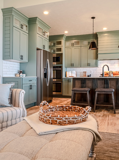 A picture of a home with green kitchen cabinets.