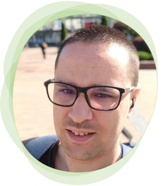 Headshot of Yurii Ishchenko with a pale green watercolor outline. He is smiling and wearing glasses.