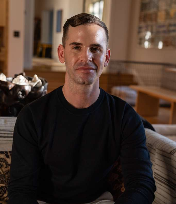 Smiling young man wearing a dark green polo shirt with Tuusulan Remonttiapu logo on a matching green background.
