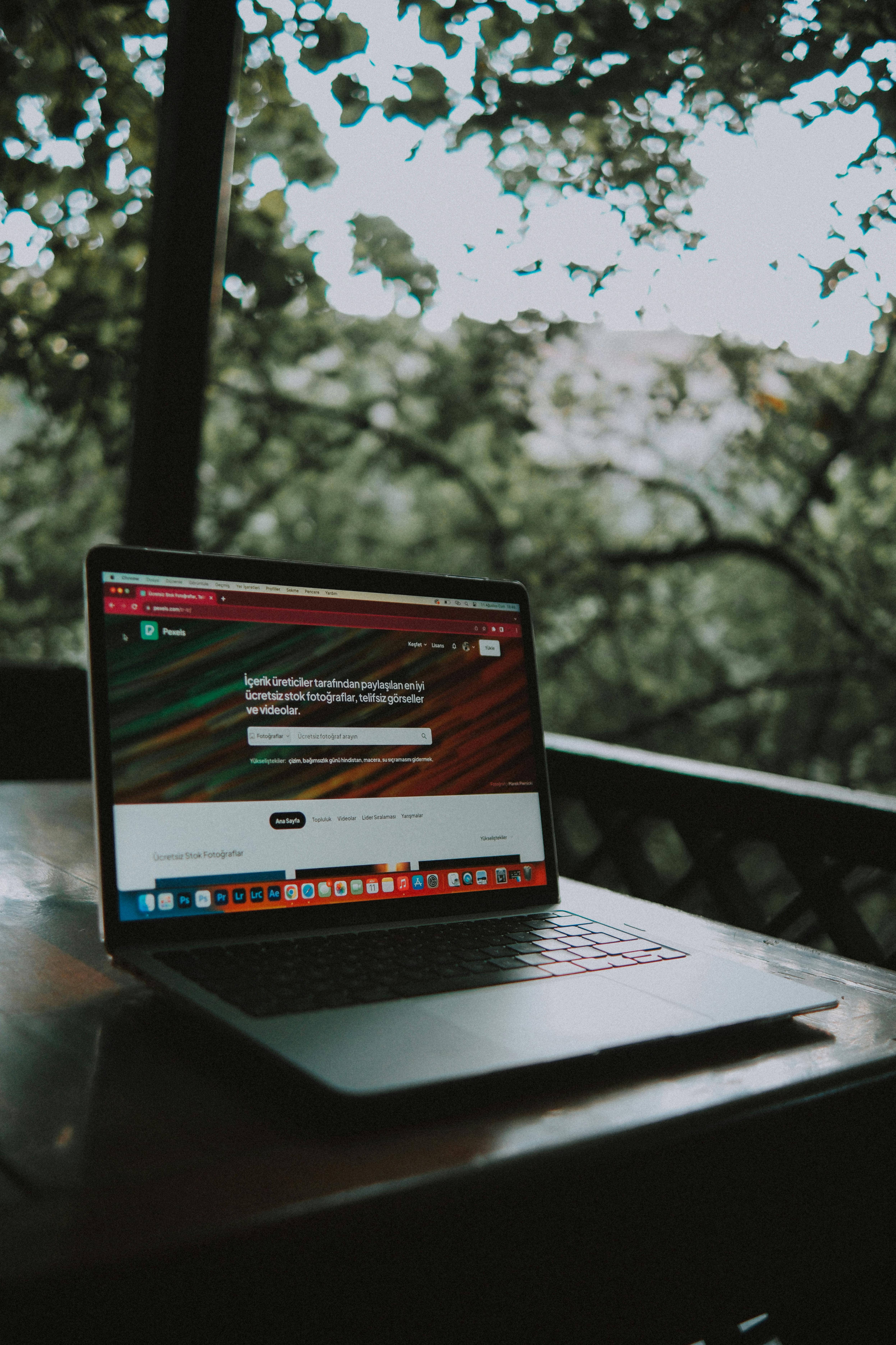 An open laptop on table with a nice foresty background