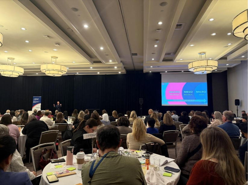 A group of people sitting at tables in a roomAI-generated content may be incorrect.