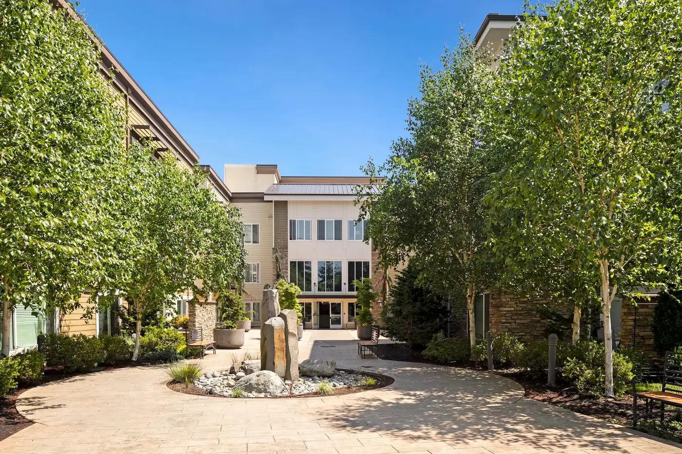 Courtyard with a fountain and trees at Summit Tower apartments in Gig Harbor