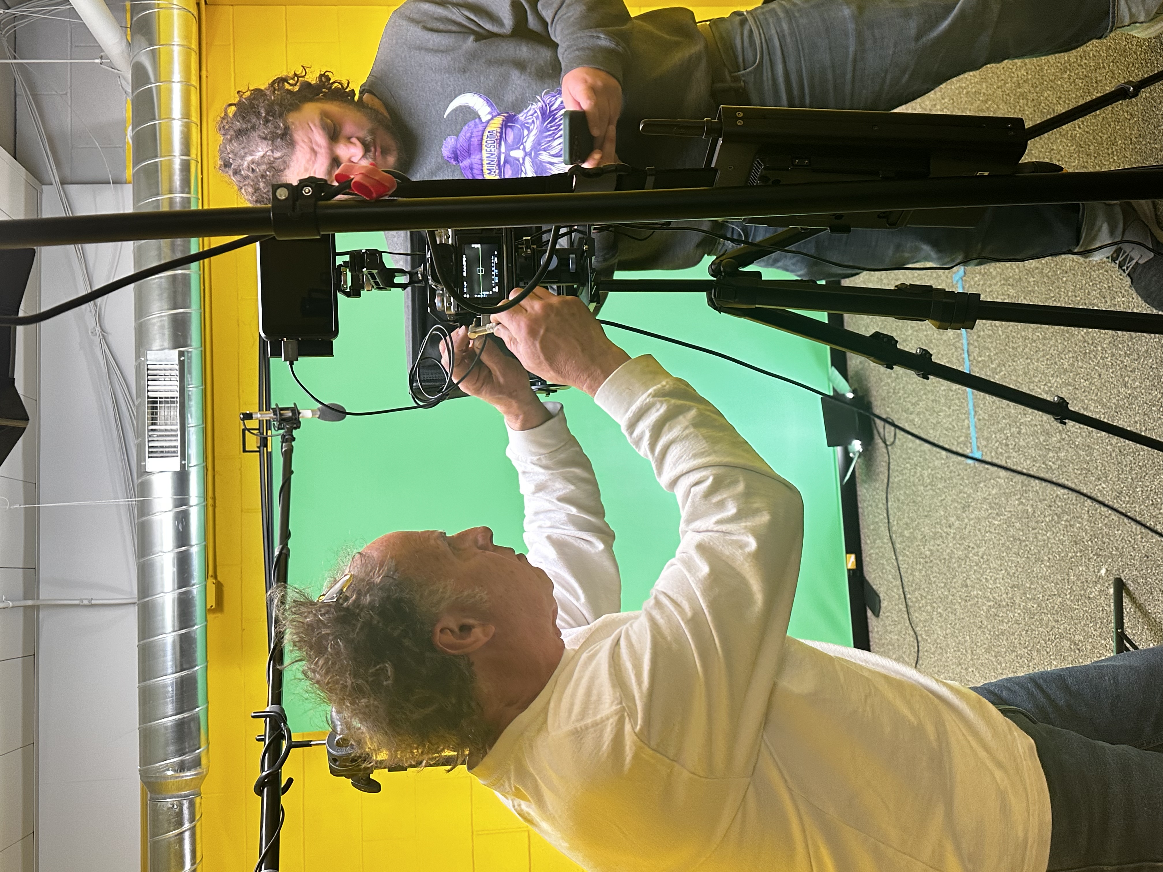 Two guys setting up the camera with tripod