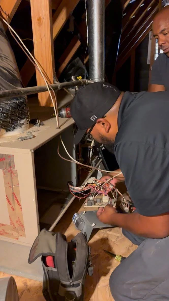 Technician working on electrical wiring in an attic or utility space