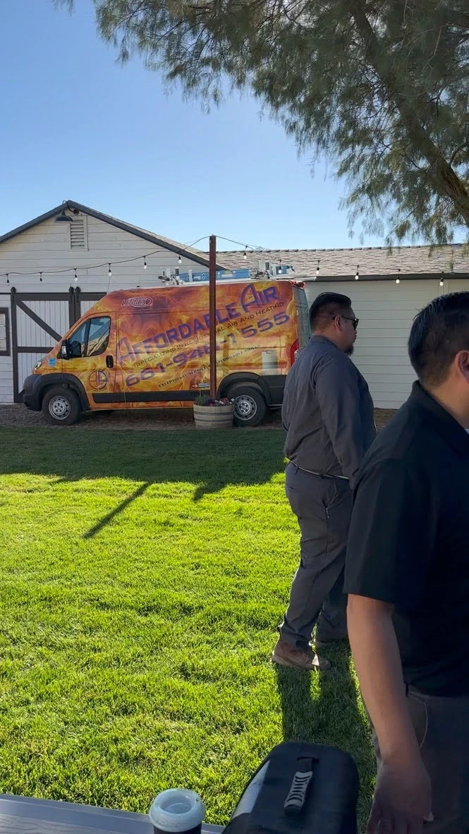 Colorful orange service van parked on green lawn near white building