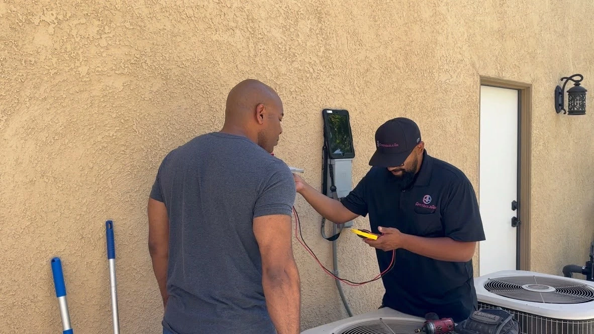 Technician checking electrical connection near air conditioning unit